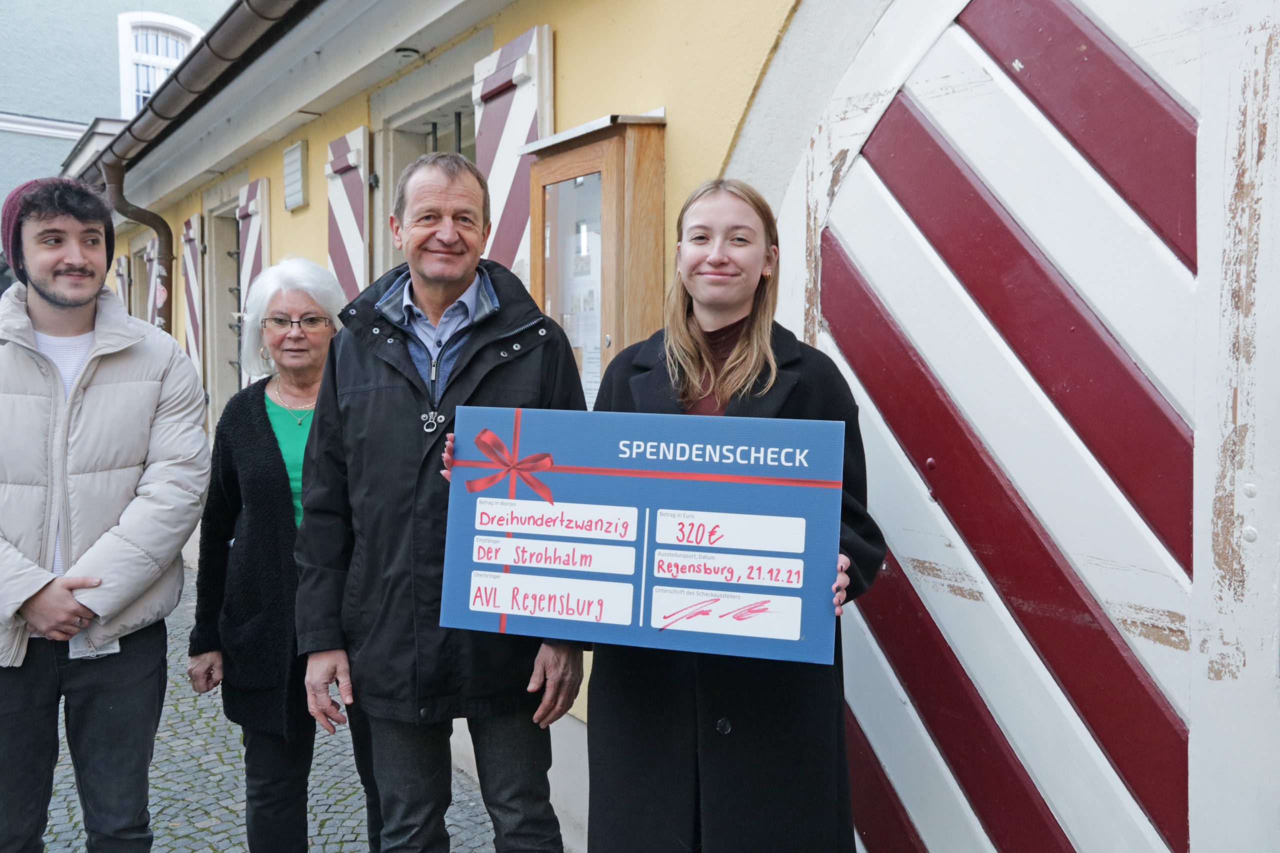 A trainee with the donation check to Strohhalm