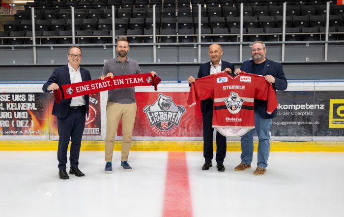 Die Geschäftsführer von AVL Software & Functions mit Vertretern der Eisbären, Fanschal und Trikot in der Eishockeyhalle Donau-Arena